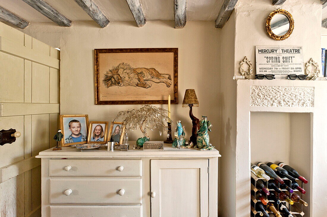 Painted sideboard with wine rack in original fireplace, Suffolk farmhouse, England, UK