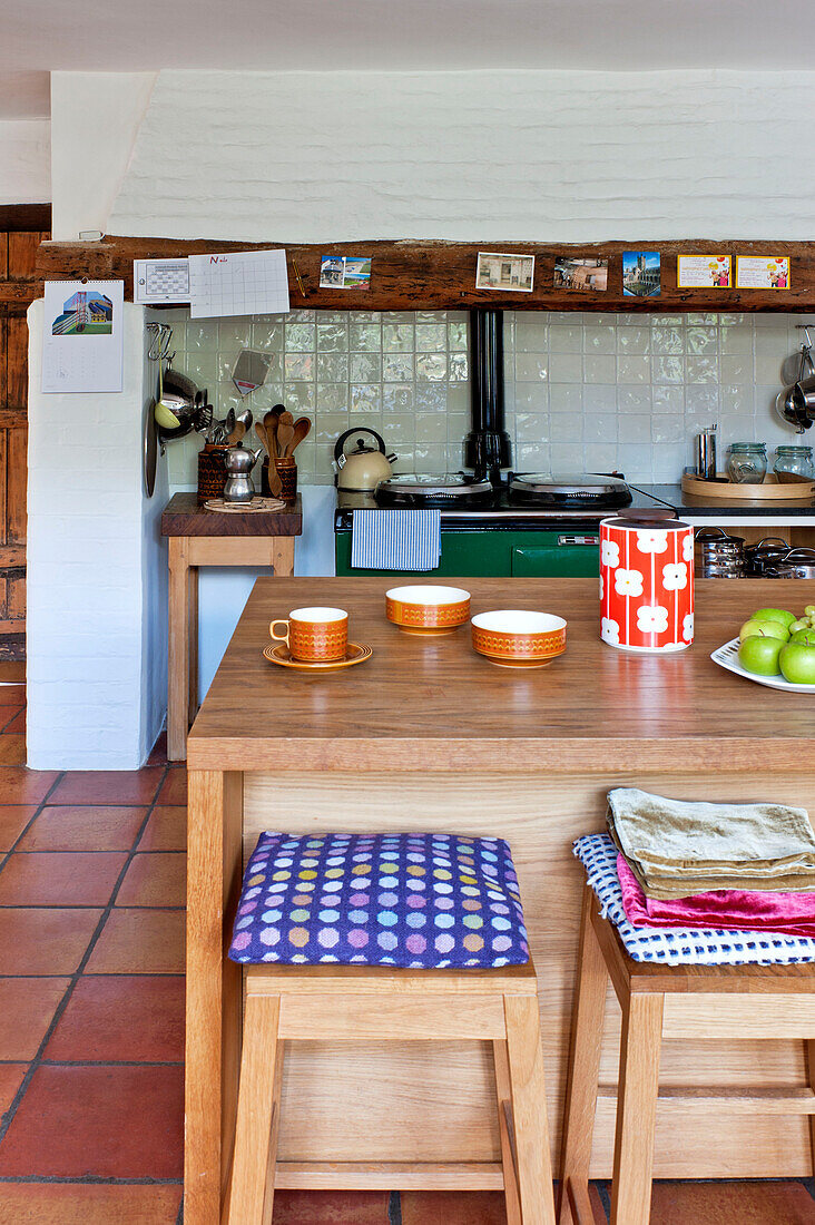 Geschirr und Vorratsdosen auf einer Kücheninsel in einem gefliesten Haus in Hertfordshire, England, UK