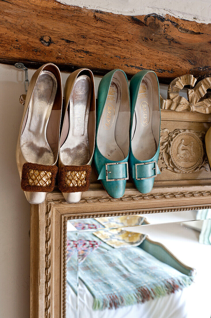 Vintage-Schuhe auf Spiegelrahmen mit Holzbalken in einem Haus in Hertfordshire, England, UK