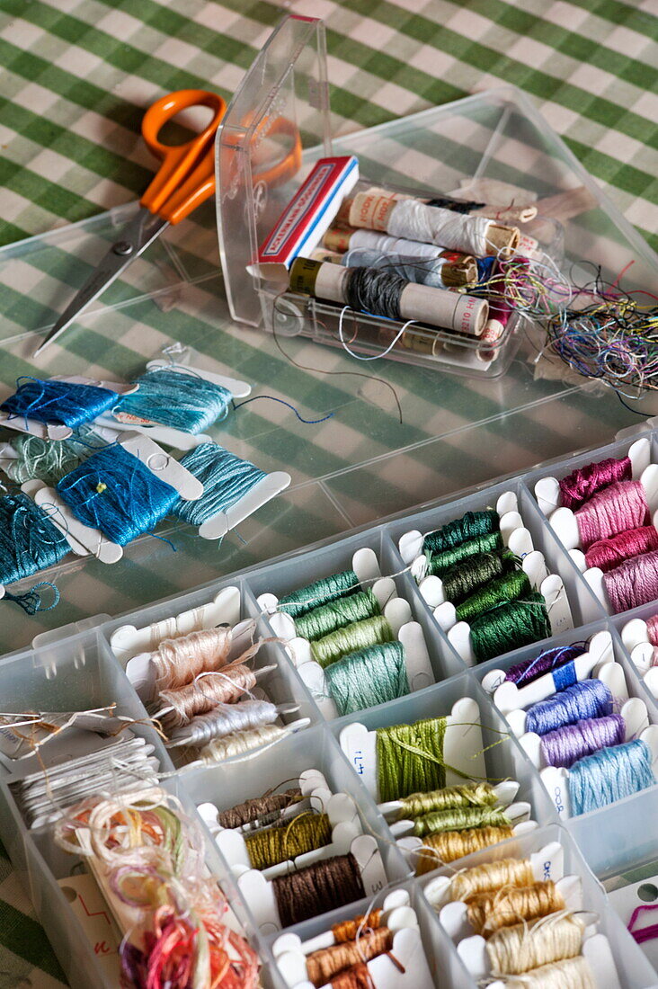 Selection of threads in a variety of colours on checked tablecloth in Padstow cottage, Cornwall, England, UK
