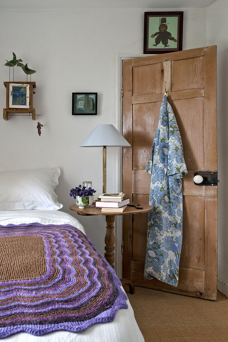 Ein geblümter Morgenmantel hängt an der Rückseite der Schlafzimmertür in einem Bauernhaus in Cornwall, England, UK