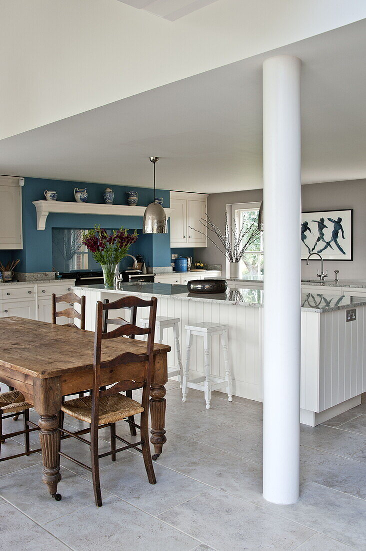 Esstisch und Stühle aus Holz in offener Küche und Esszimmer eines modernen Landhauses in Suffolk, England, UK