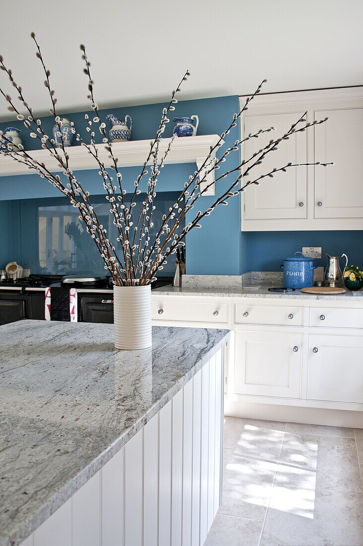 Pussy willow arrangement on marble topped kitchen surface in contemporary Suffolk country house, England, UK
