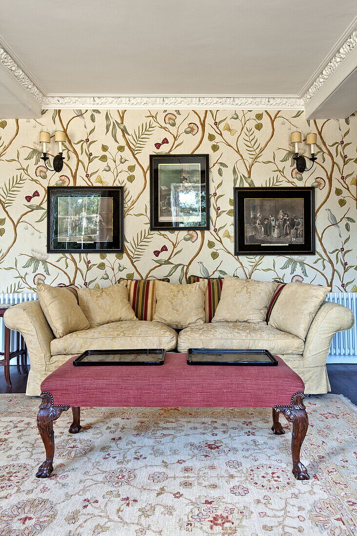 Kunstwerk über dem Sofa im Wohnzimmer mit gemusterter Tapete, modernes Landhaus in Suffolk, England, UK