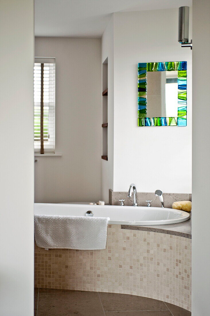 Mosaikgefliestes Bad mit Buntglasspiegel in einem modernen Haus, Cornwall, England, UK