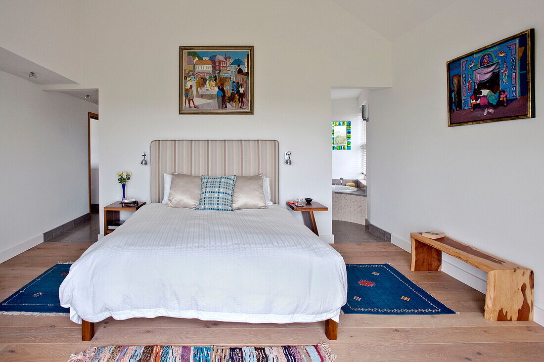 Blauer Teppich auf dem Boden eines Doppelschlafzimmers mit eigenem Bad in einem modernen Haus, Cornwall, England, UK