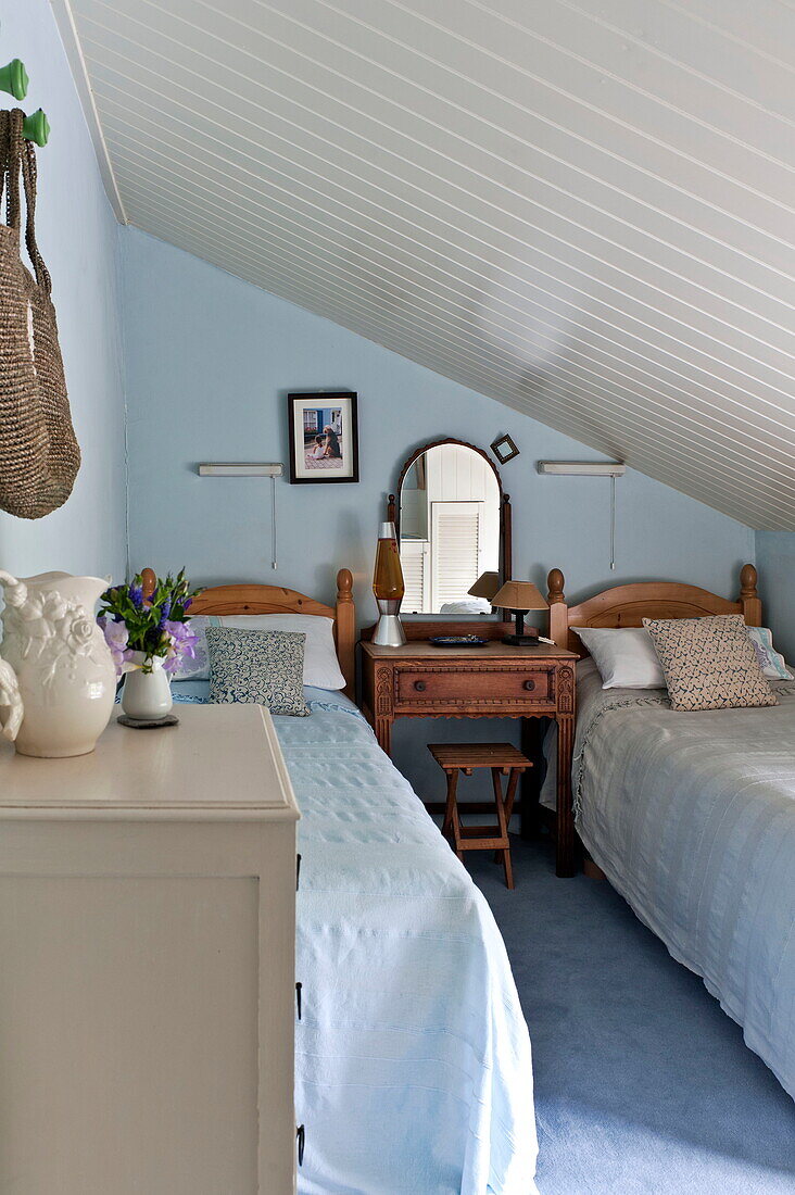 Light blue twin bedroom in attic of Padstow cottage, Cornwall, England, UK
