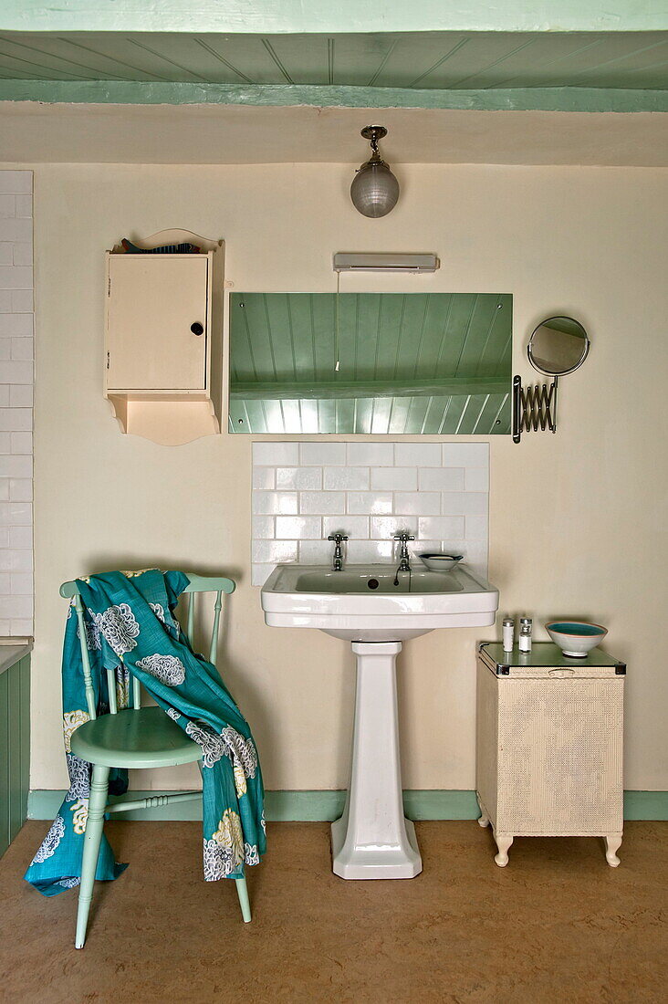 Stehendes Waschbecken unter Spiegel im Badezimmer eines Cottages in Padstow, Cornwall, England, UK