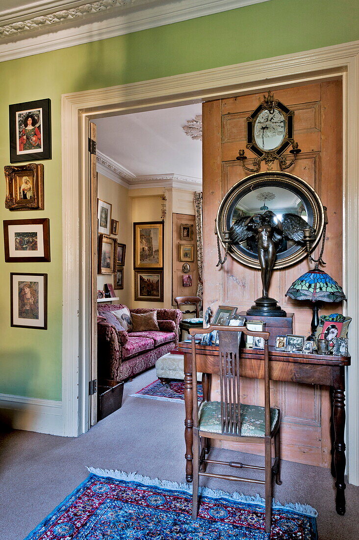 Konvexer Spiegel und geflügelte Figur mit Schreibtisch und Stuhl in einem Haus in London, England, UK