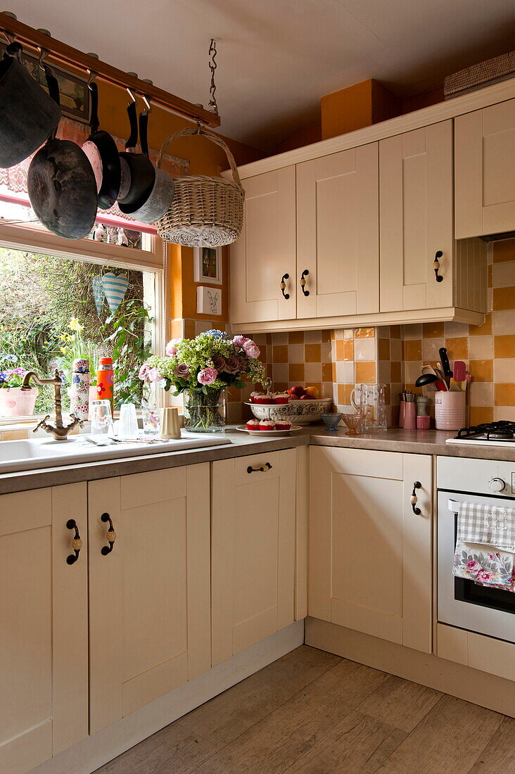 Weiße Einbauschränke mit karierter Spritzwand in der Küche eines Hauses in London, England, UK