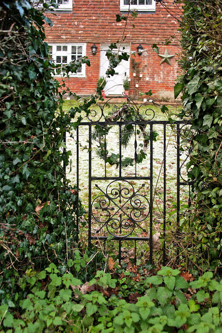 Blumenkranz am Eisentor eines Cottage in Shropshire, England, Vereinigtes Königreich