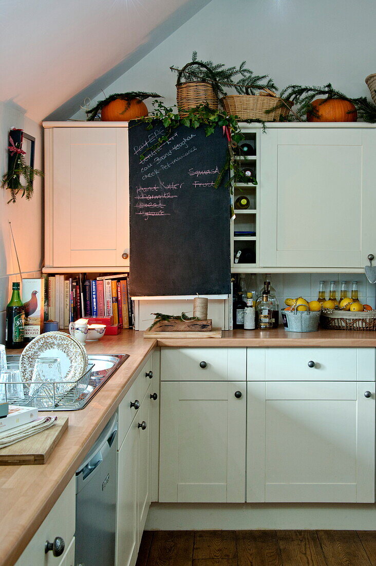 Chalkboard in white fitted kitchen of Shropshire cottage, England, UK