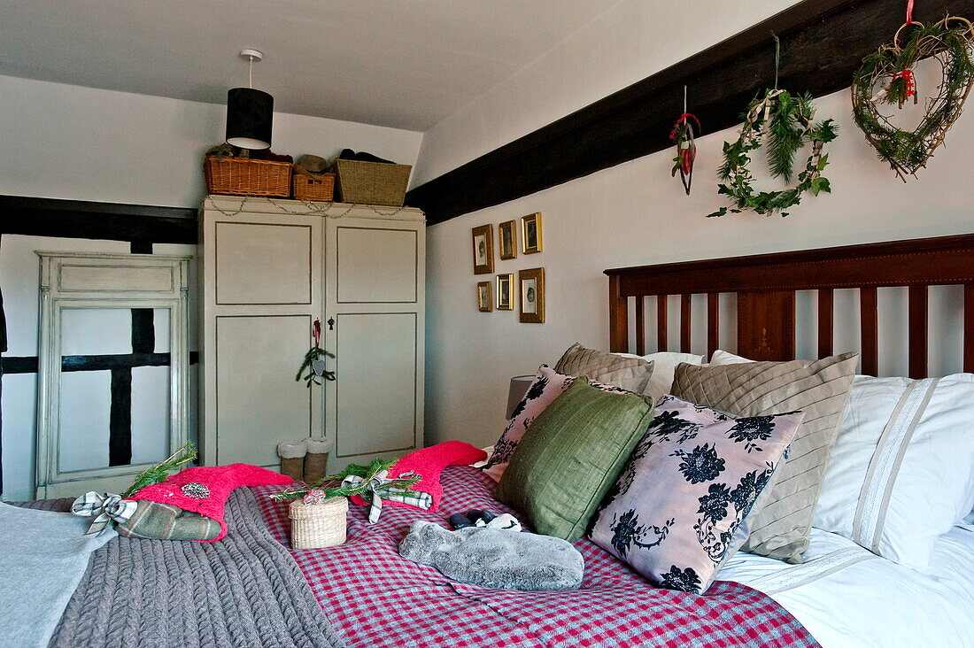 Christmas stockings and hot water bottle on bed in timber framed Shropshire cottage, England, UK