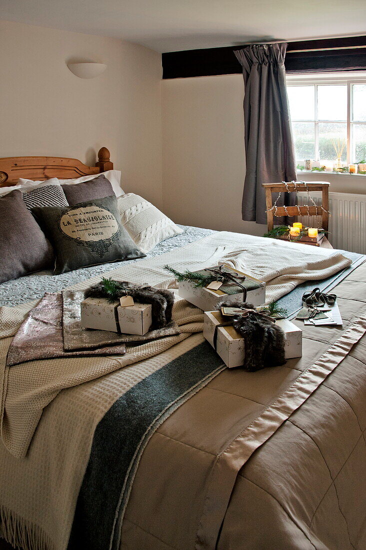 Eingepackte Geschenke auf einem Doppelbett in einem Landhaus in Shropshire, England, UK