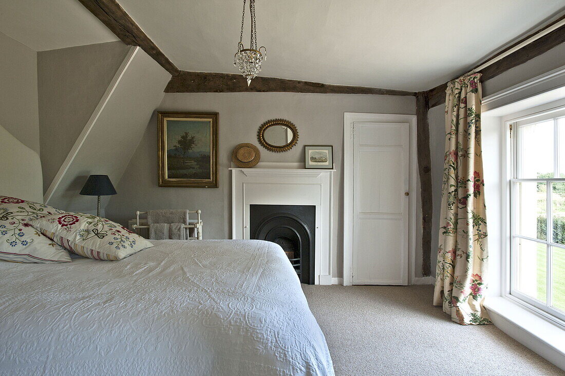 Bestickte Kissen im Bett eines modernen Landhauses in Suffolk, England, UK
