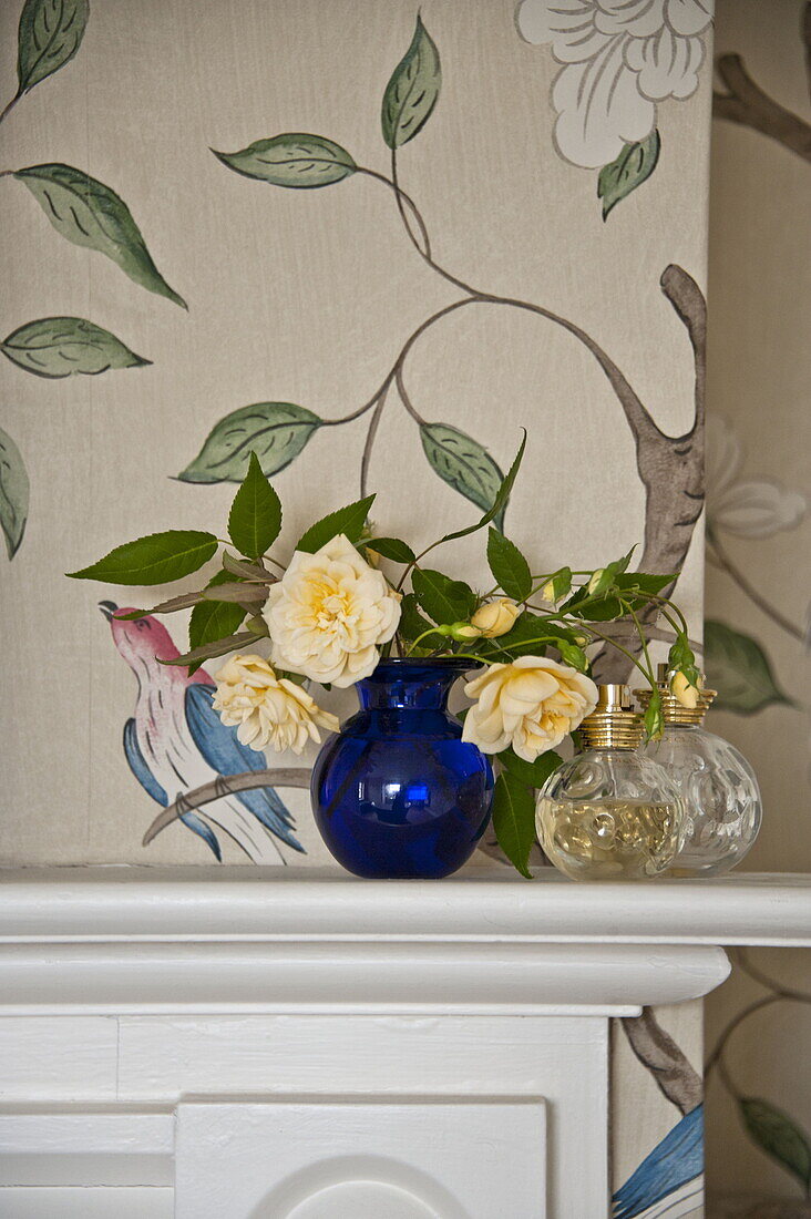 Yellow roses in blue vase on mantlepiece in contemporary Suffolk country house, England, UK