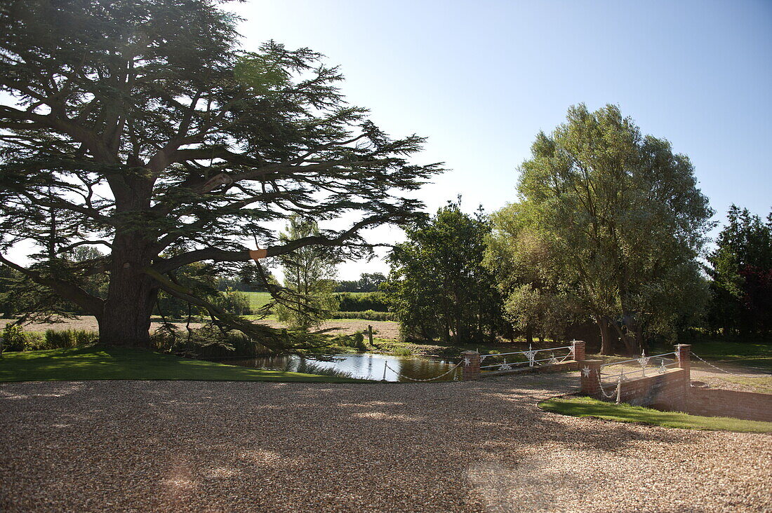 Gravel driveway and bridge access in grounds of Suffolk country house, England, UK