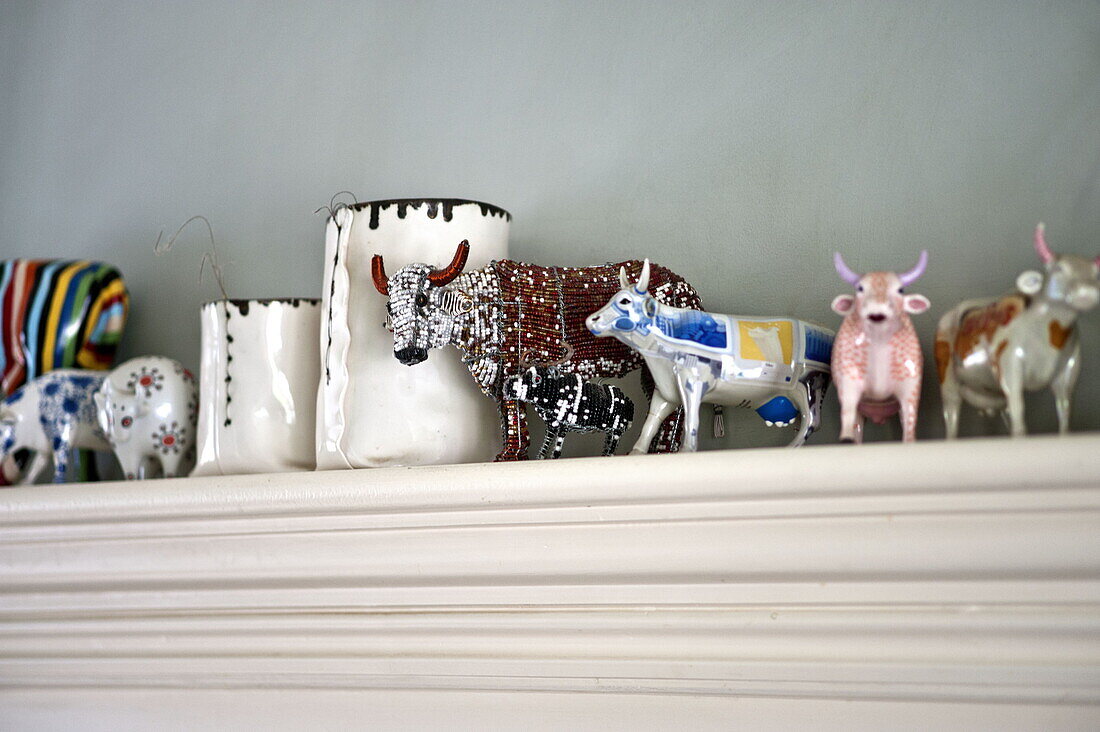 Assorted cow figurines on shelf in kitchen of contemporary Suffolk/Essex home, England, UK