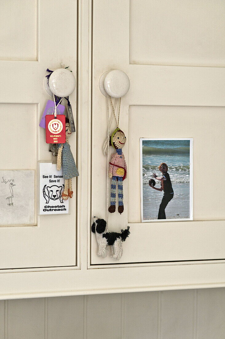Rag dolls and photos on cupboard in contemporary Suffolk/Essex home, England, UK
