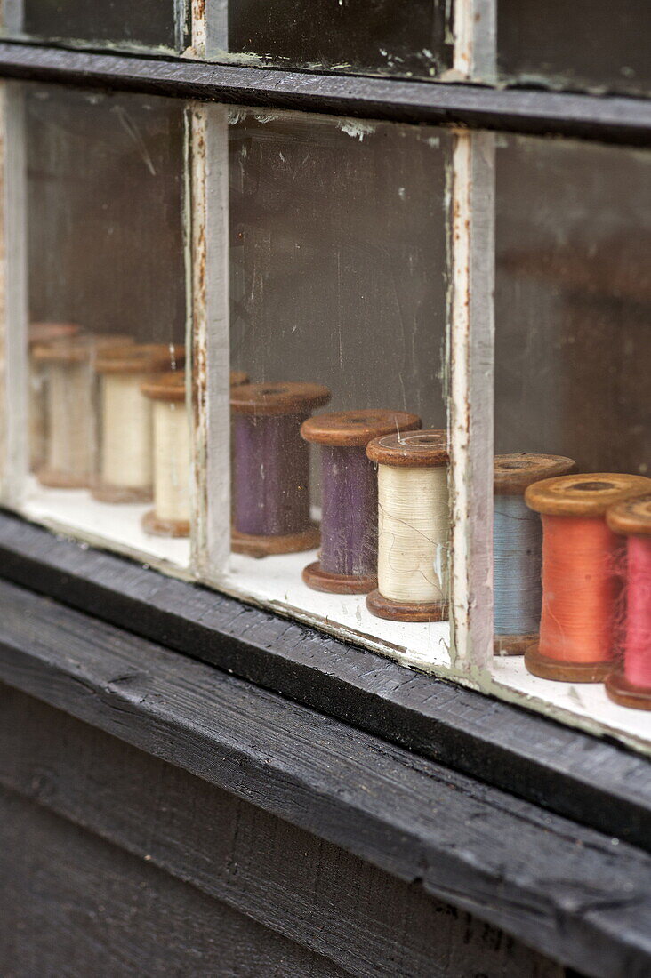 Fadenspulen auf der Fensterbank eines Hauses in Suffolk/Essex, England, UK