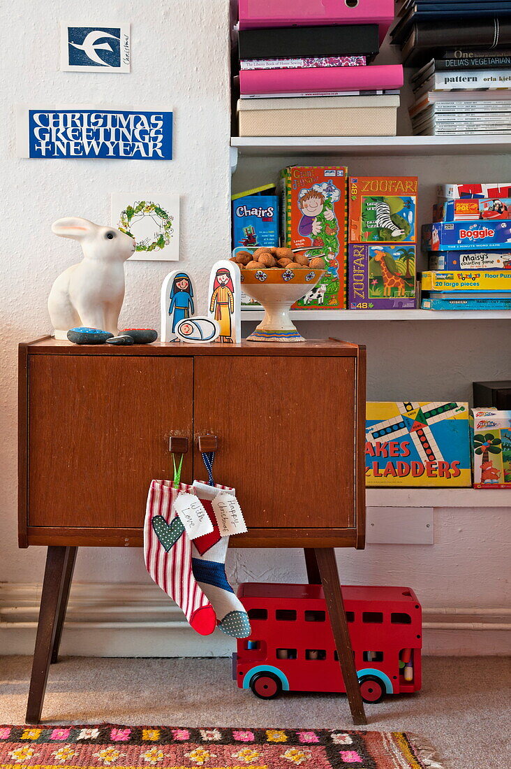 Wooden sideboard with children's toys on shelves in Penzance cottage Cornwall England UK