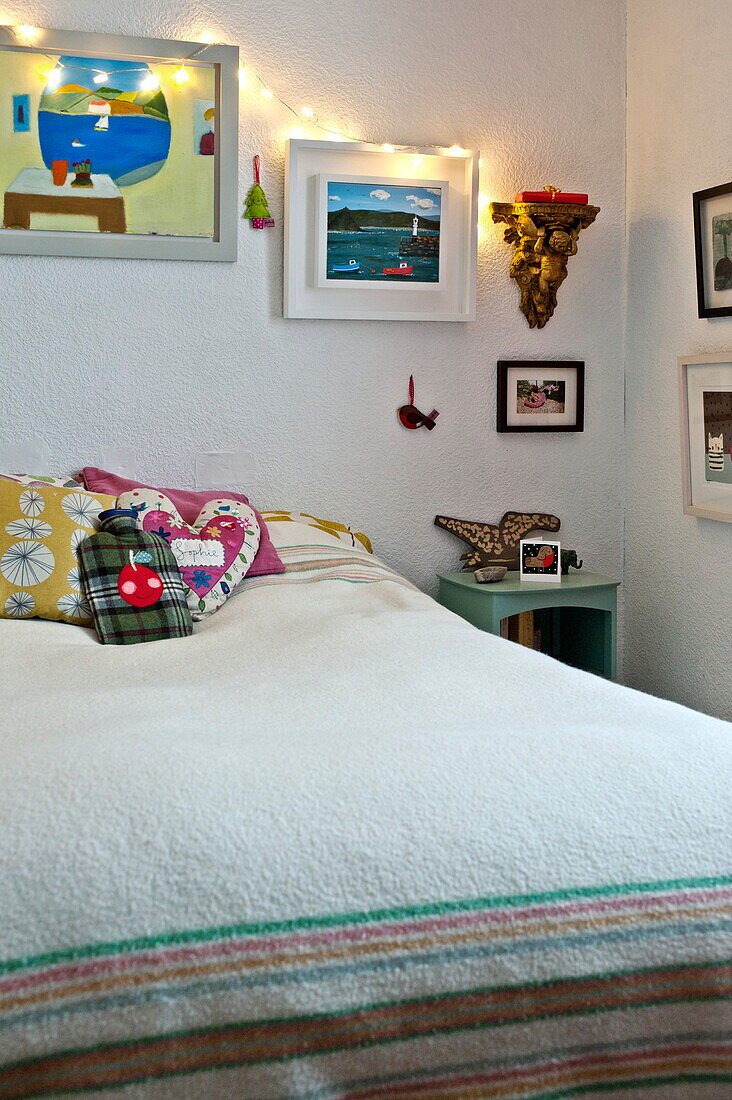 Fairylights on artwork above bed in Penzance cottage Cornwall England UK