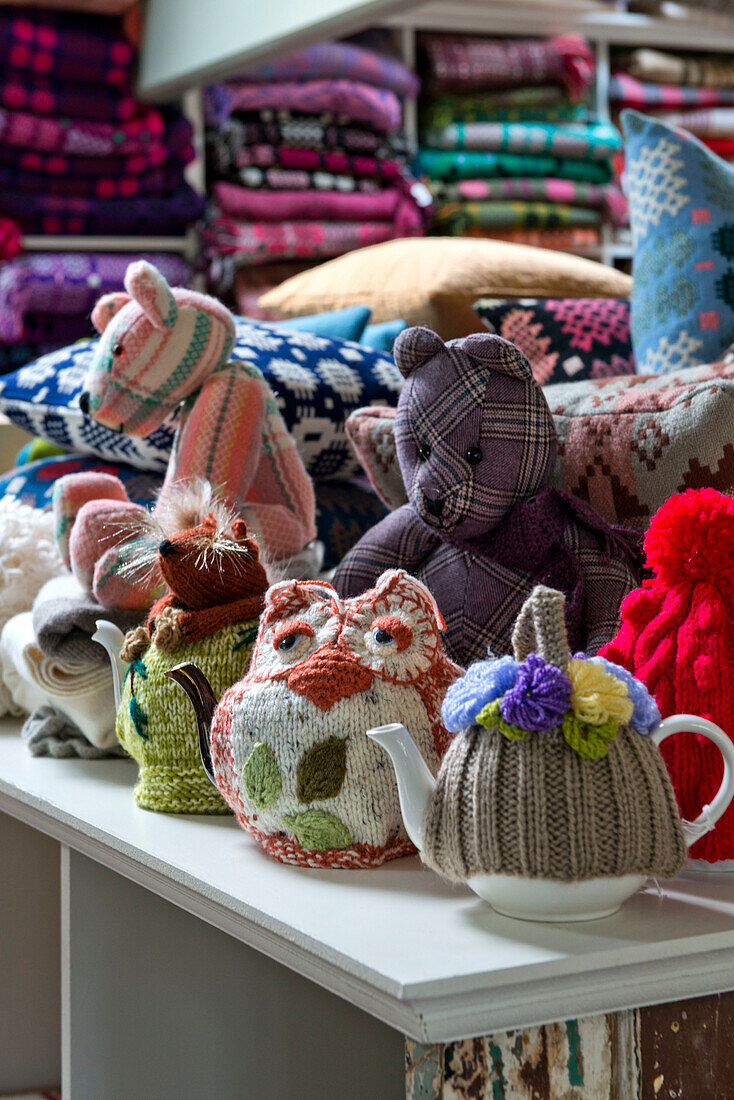 Teewärmer und Plüschtiere mit Wolldecken in einem Geschäft in Tregaon, Wales, UK