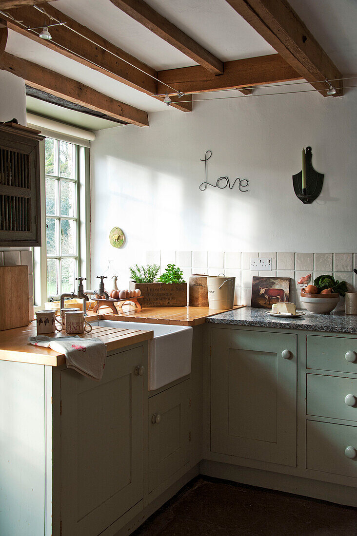 "Küchenspüle mit dem Schriftzug Love"" am Fenster der umgebauten Scheune in Sherford, Devon, Großbritannien"""