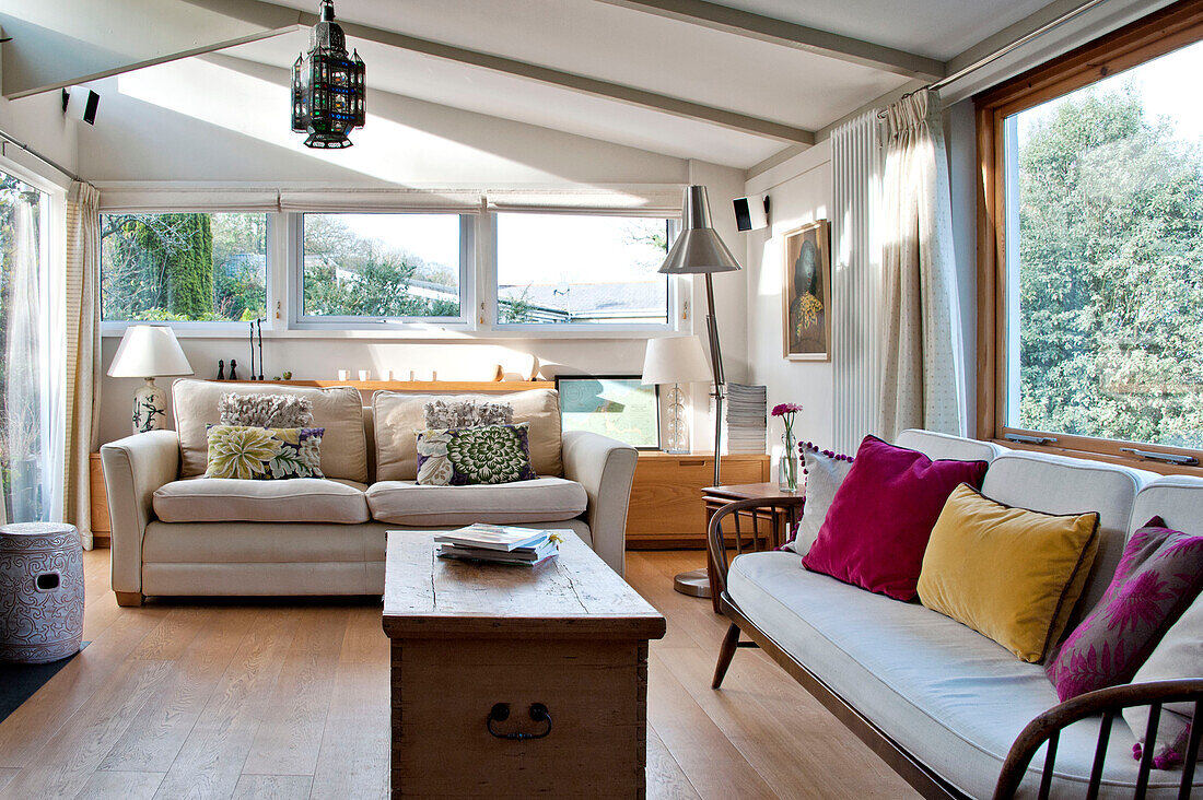 Zweisitzer und Holzsofa im Stil der 1940er Jahre im Wohnzimmer im Obergeschoss eines Hauses in Cornwall, Vereinigtes Königreich