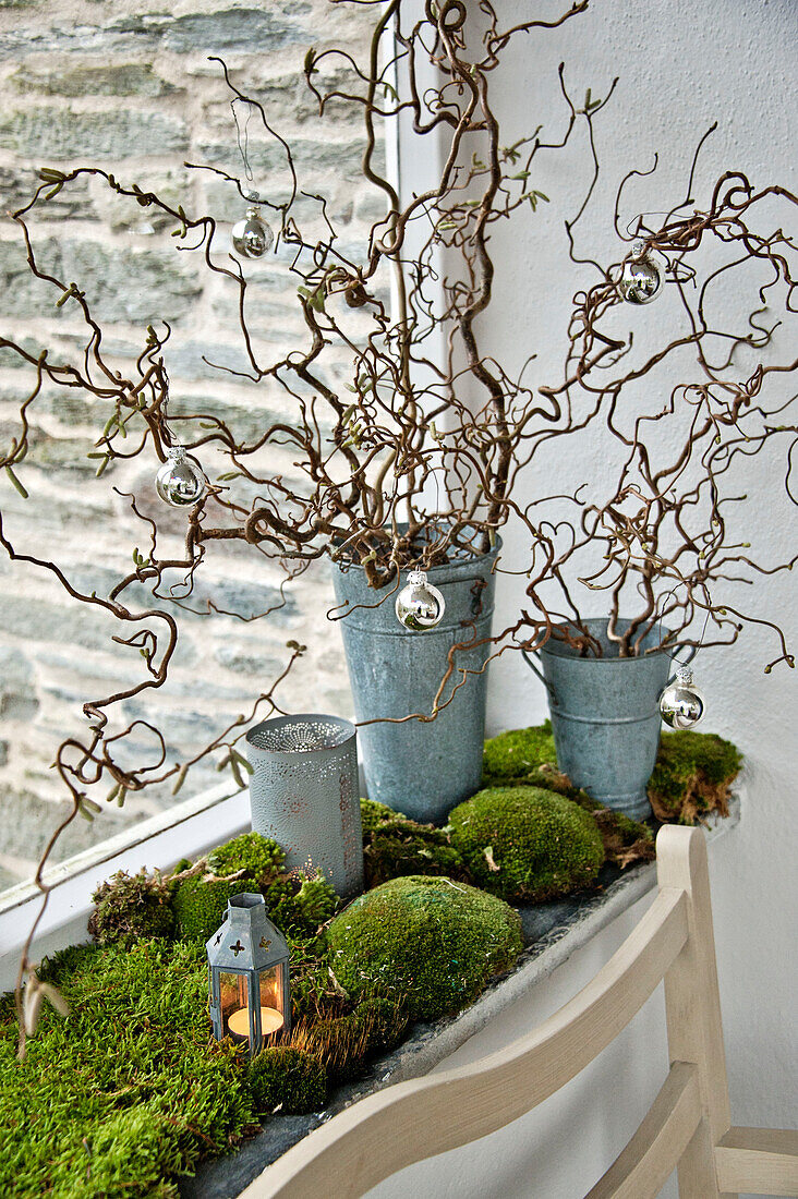 Silver baubles on twig arrangement with moss in Crantock porch Cornwall England UK