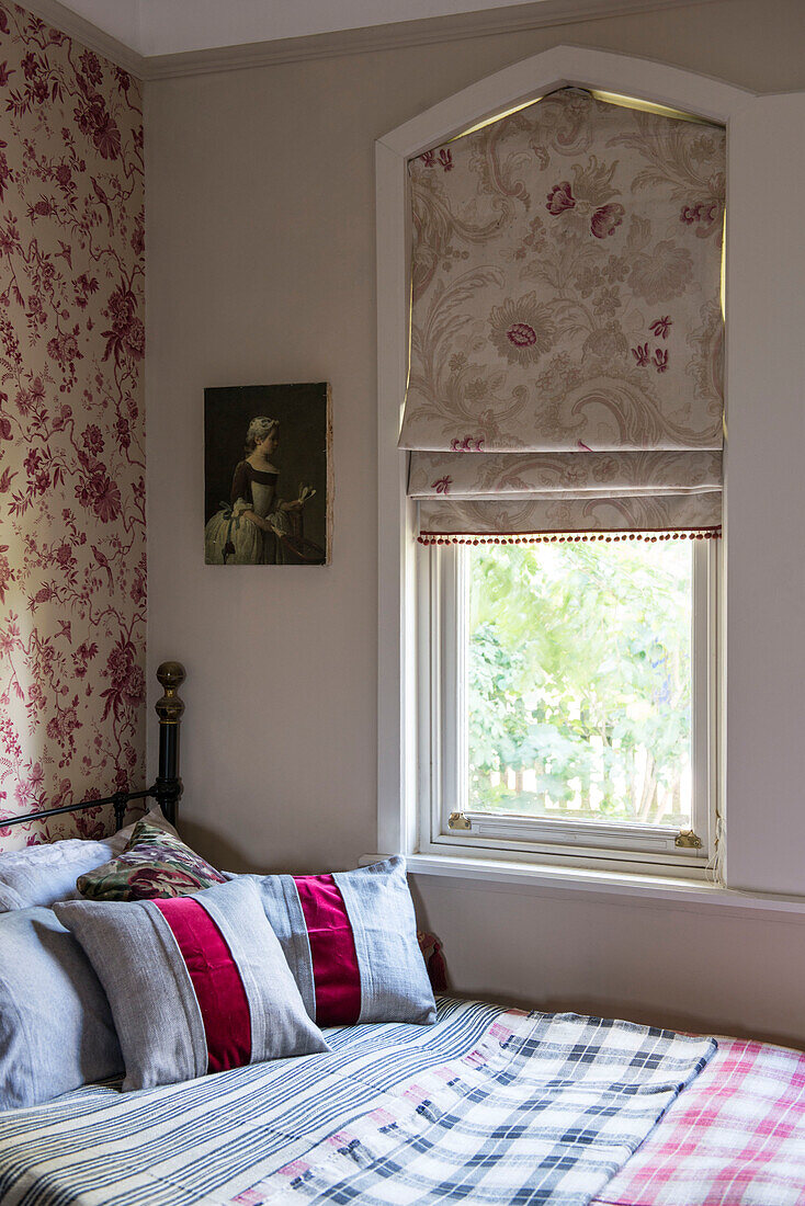Raffrollos am Fenster über dem Bett mit scharlachrot gestreiften Kissen in einem Haus in Stamford Lincolnshire England UK