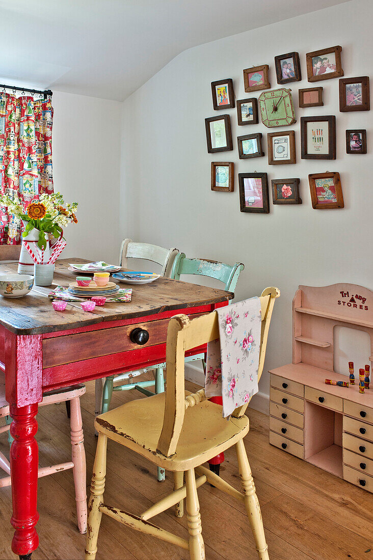 Gerahmtes Kunstwerk mit bemaltem Küchentisch und Stühlen in einem Landhaus in Cambridge England UK