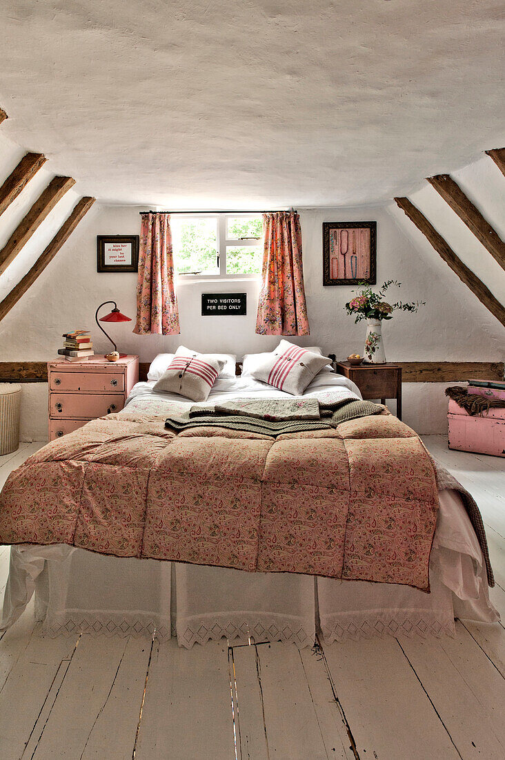 Doppelbett am Fenster in einem Fachwerkschlafzimmer in einem Cottage in Cambridge, England, UK