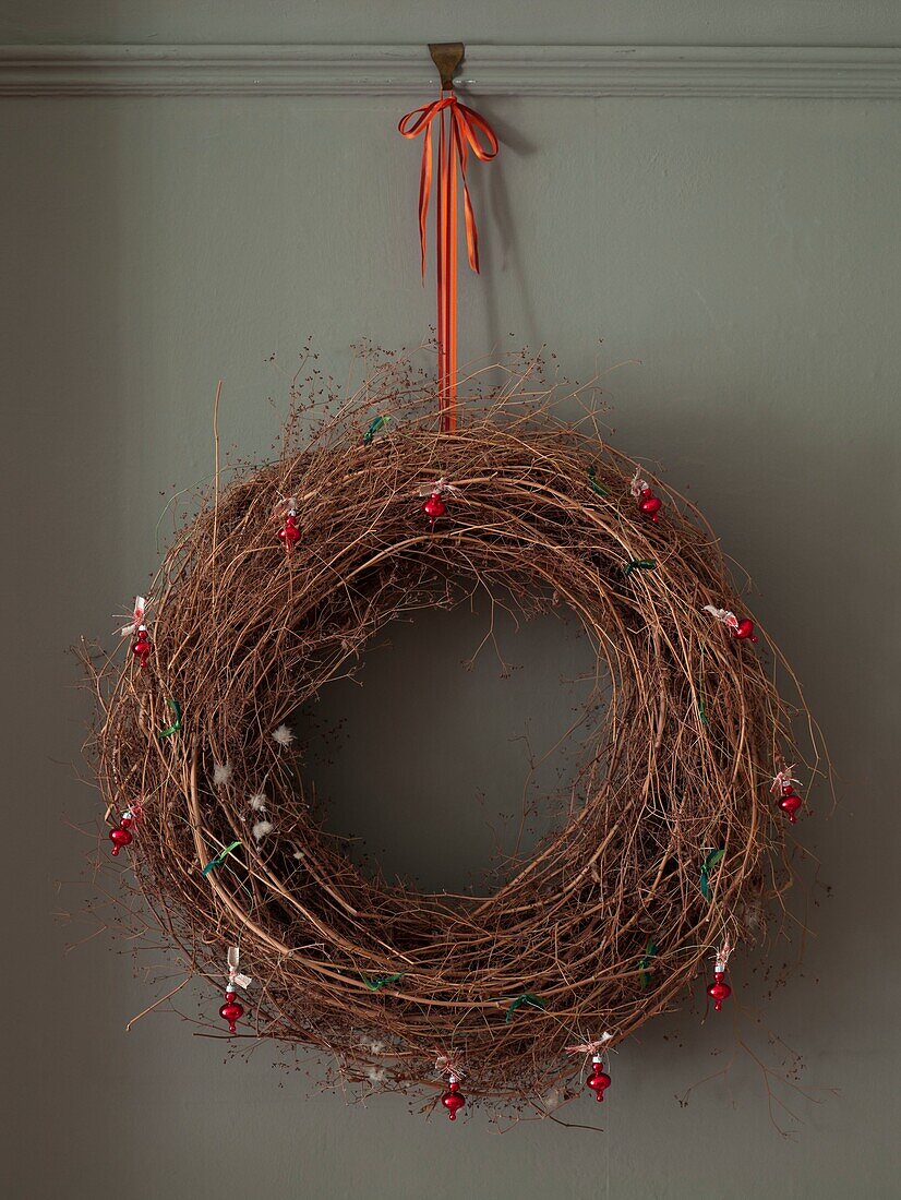 Christmas wreath hangs on orange ribbon in London home England UK