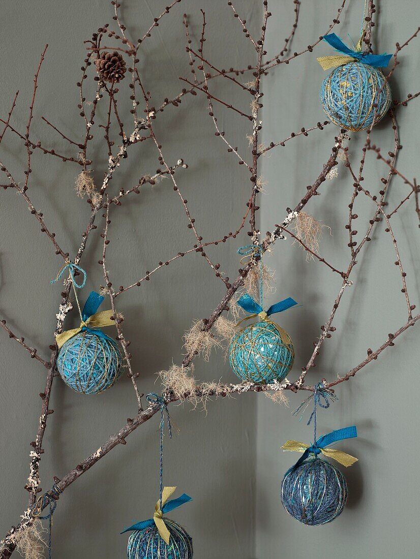 Handgefertigte Weihnachtskugeln hängen an einem Zweig in einem Londoner Haus in England UK
