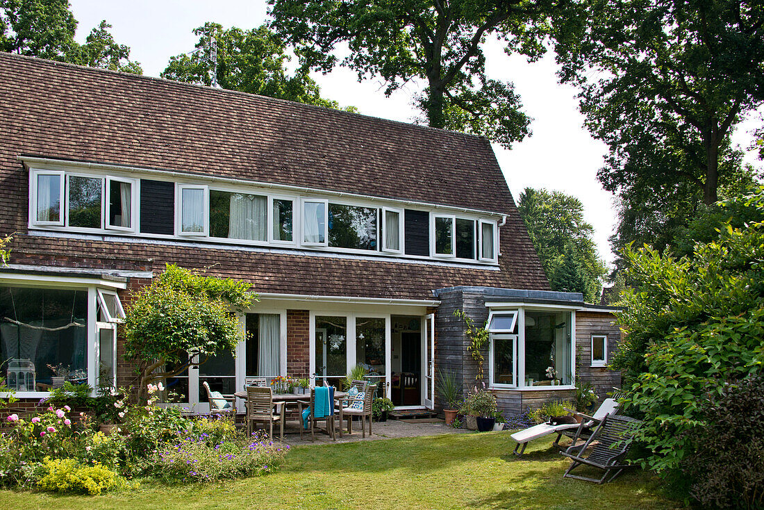 Terrassenmöbel an der Außenseite eines zweistöckigen Einfamilienhauses in East Grinstead, Sussex, England UK