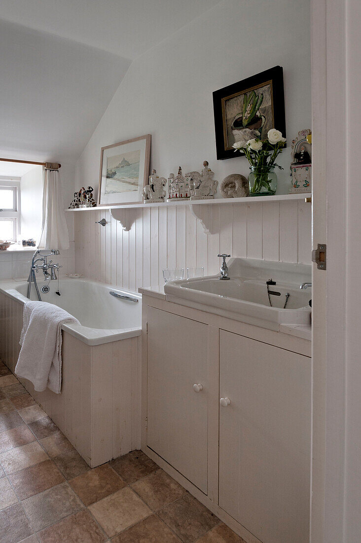 White panelled bathroom with ornaments on shelf in beach house Cornwall England UK
