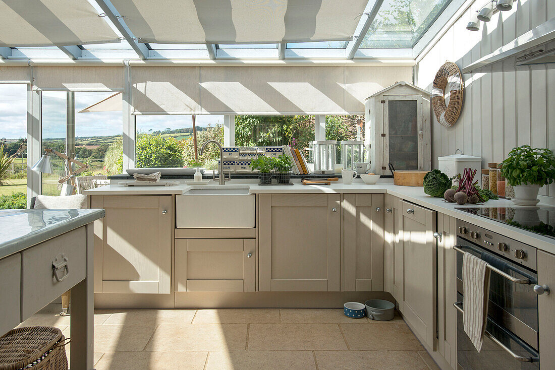 Roller blinds in sunlit kitchen extension of Penzance farmhouse Cornwall England UK