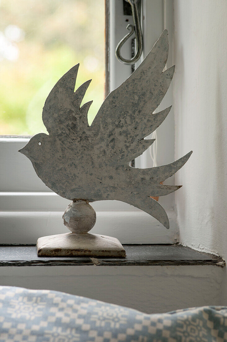 Metallischer Vogel auf der Fensterbank in einem Bauernhaus in Penzance, Cornwall, England, UK