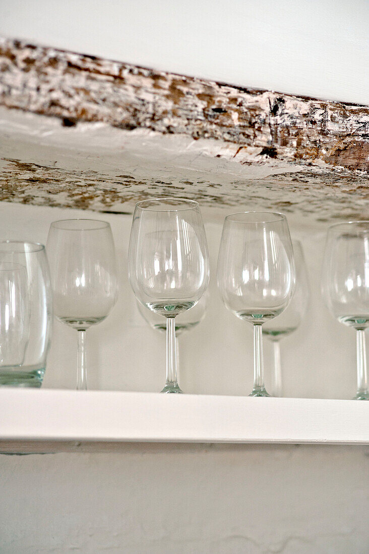 Wineglasses on shelf with wooden lintel in family townhouse Cornwall England UK