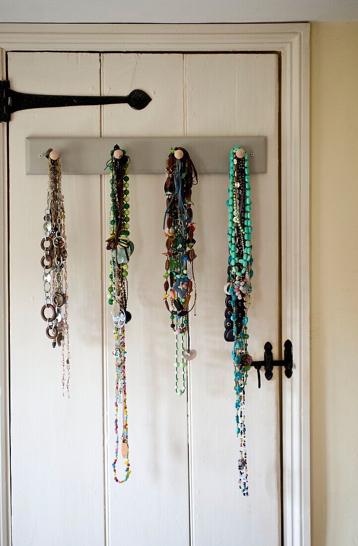 Halsketten hängen an der Rückseite der Tür im Schlafzimmer in Edworth, Bedfordshire, England, UK