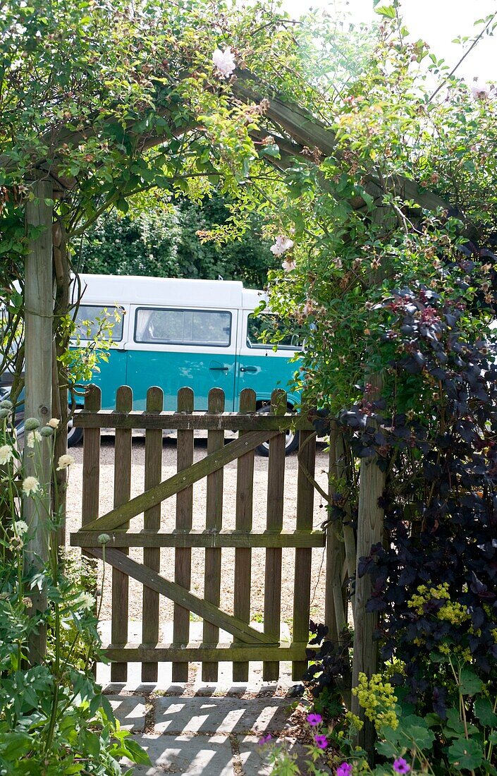 Blick durch die Pergola und das Tor zum geparkten Wohnmobil in Edworth Bedfordshire England UK