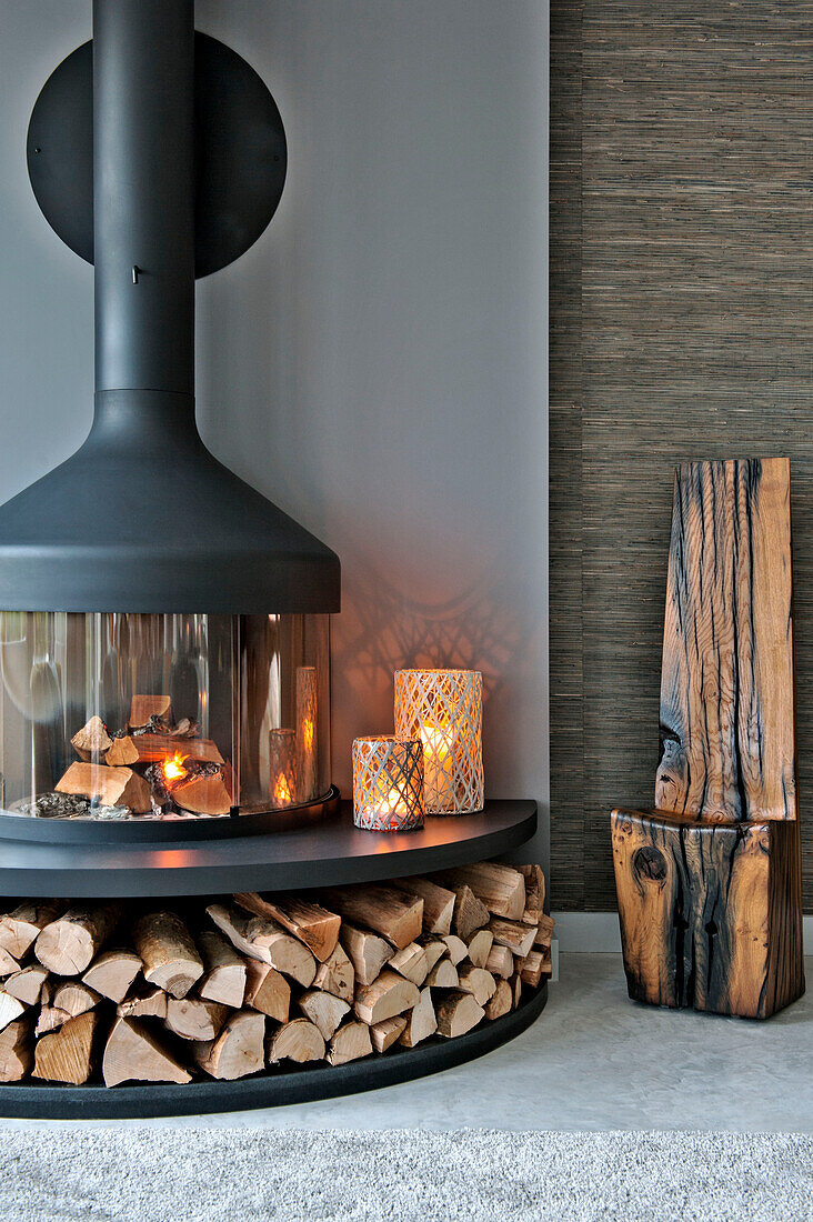 Moderner Kamin mit Brennholz im Wohnzimmer von Lechlade Gloucestershire England UK