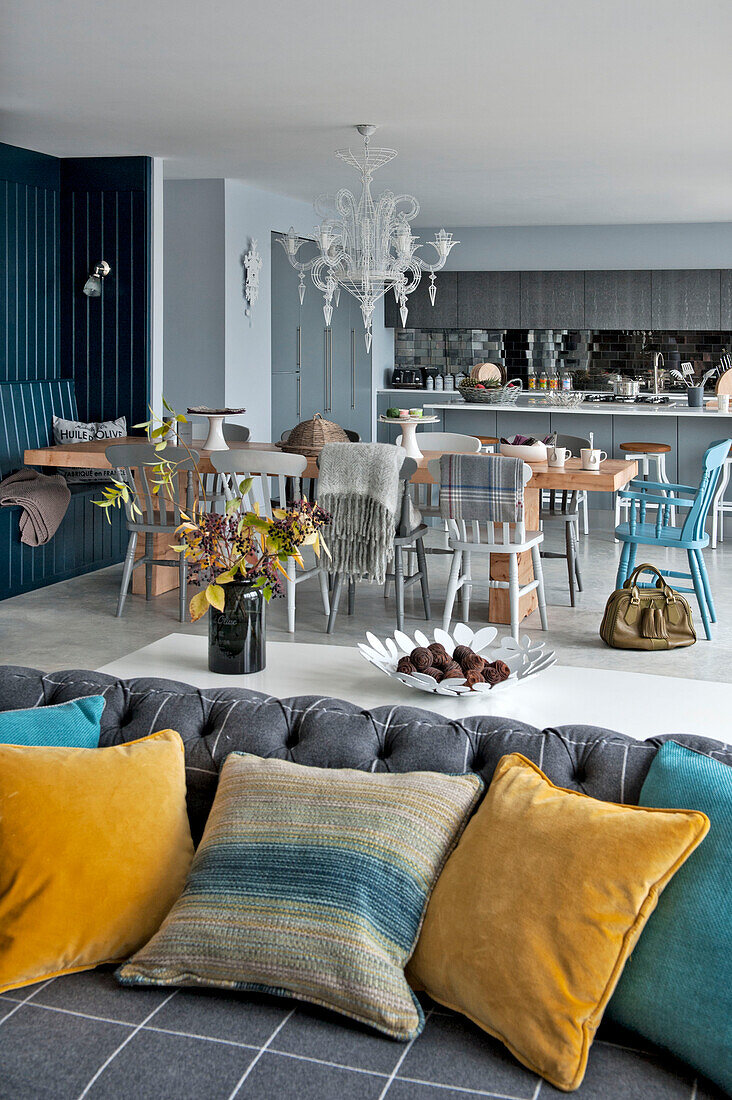 Yellow and turquoise velvet cushions on grey sofa in open plan Lechlade home Gloucestershire England UK