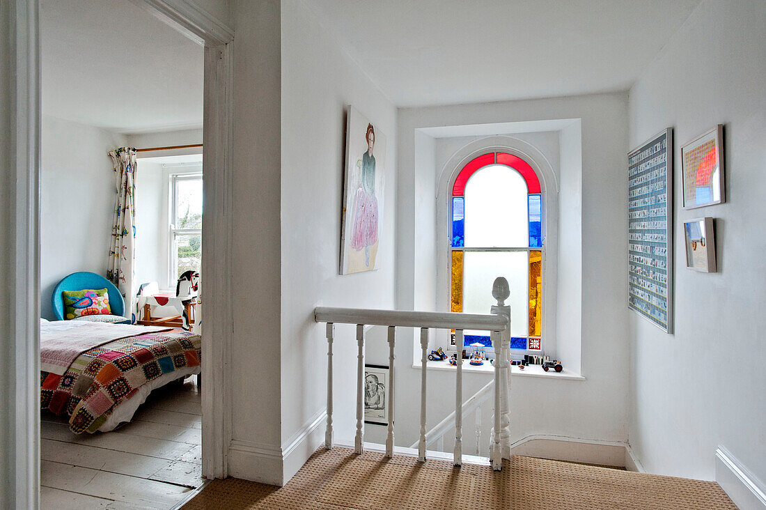 Flur mit Buntglasfenster und Blick in das Schlafzimmer eines Ferienhauses in Cornwall UK