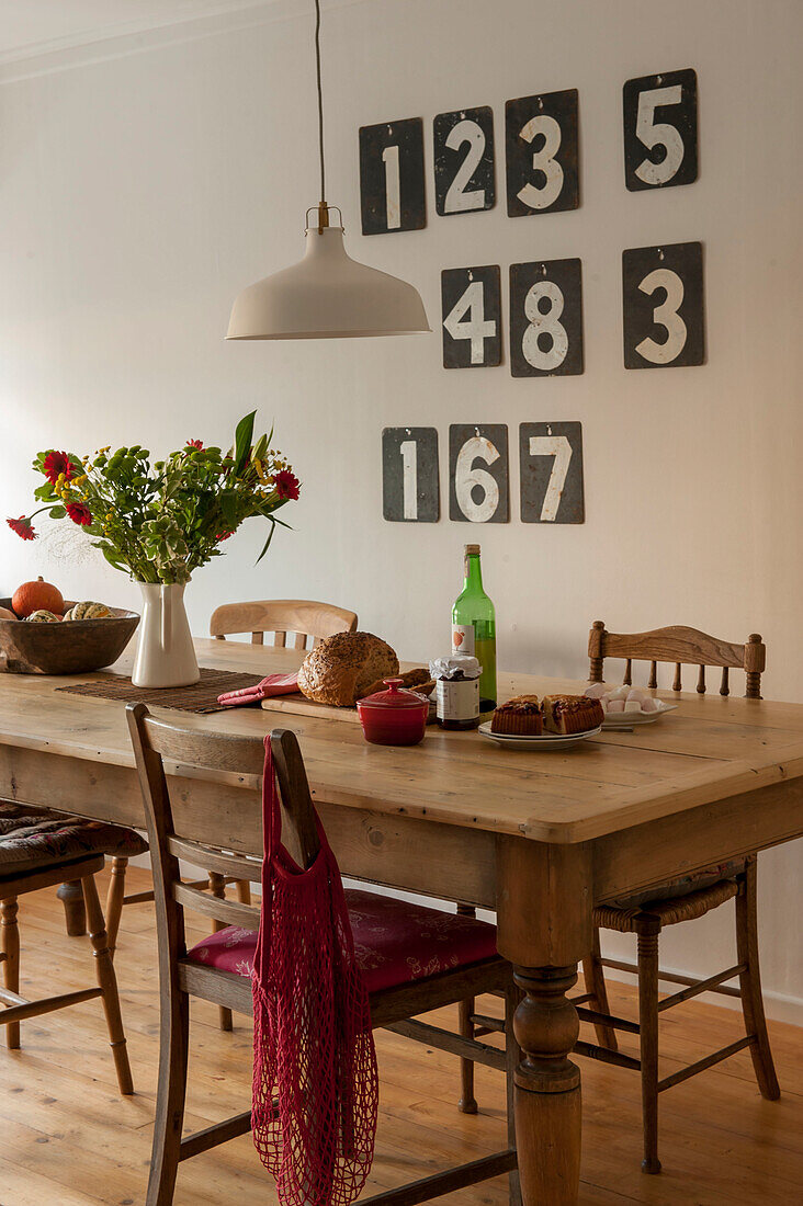 Wooden dining table and chairs with numbers in Cornwall cottage UK