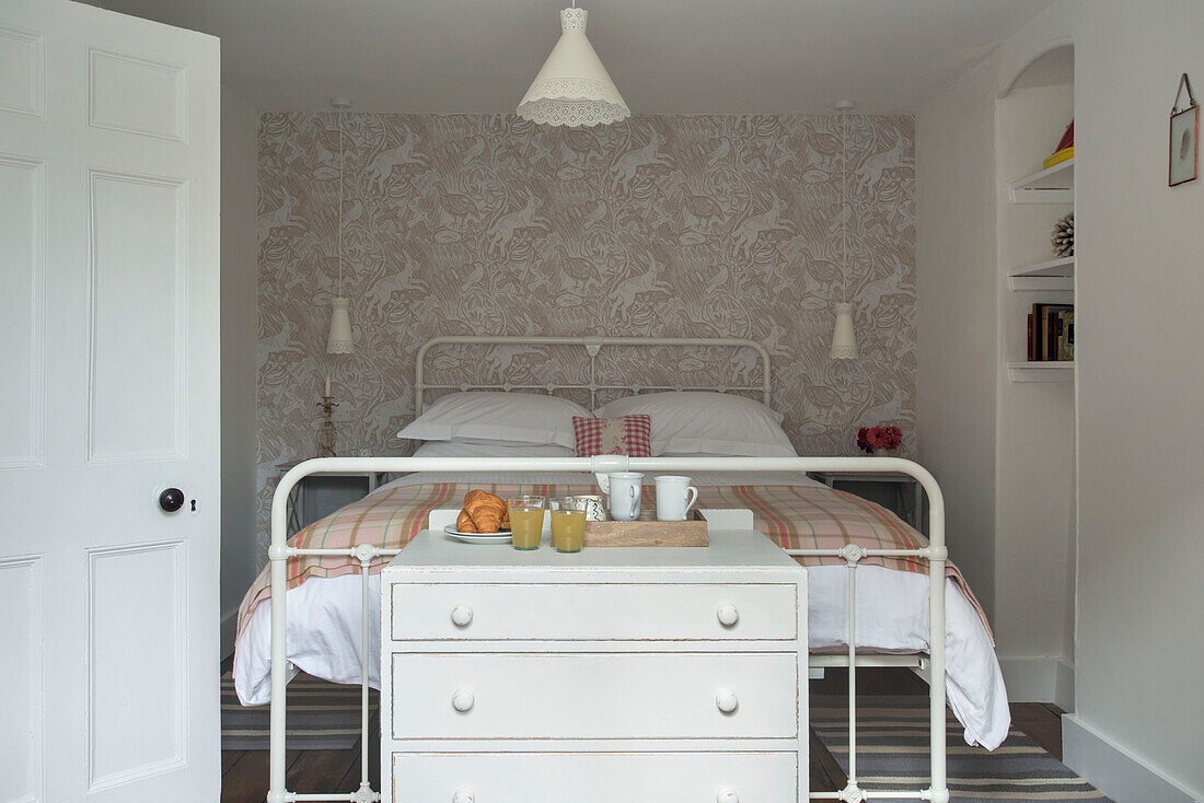 Tartan-Decke auf Doppelbett mit Frühstückscroissants auf Kommode Cornwall UK