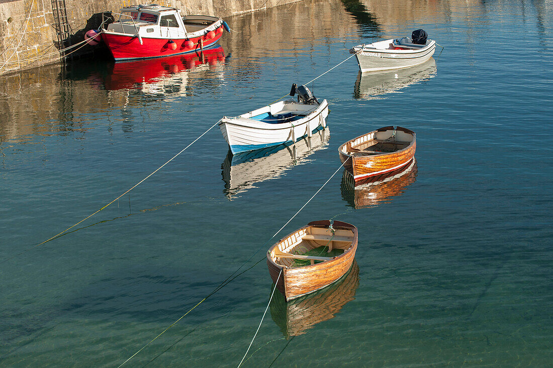 Boats moored in Mousehole harbour Cornwall UK