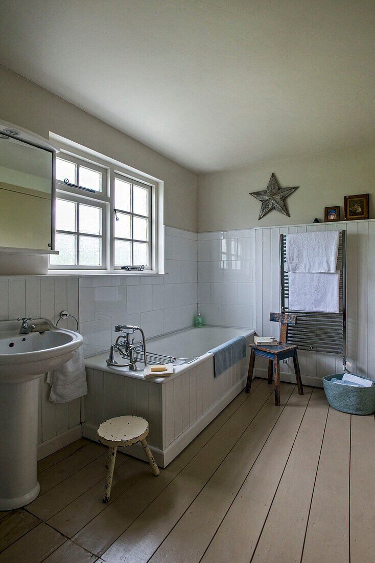 White tiled bathroom with painted floorboards in St Erth bathroom Cornwall UK