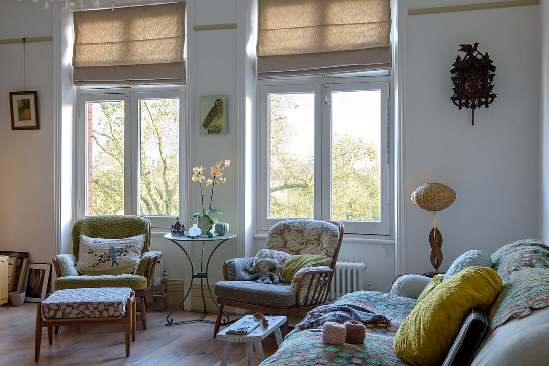 Wollknäuel auf Sofa mit passenden Sesseln in Fenster einer Londoner Wohnung UK